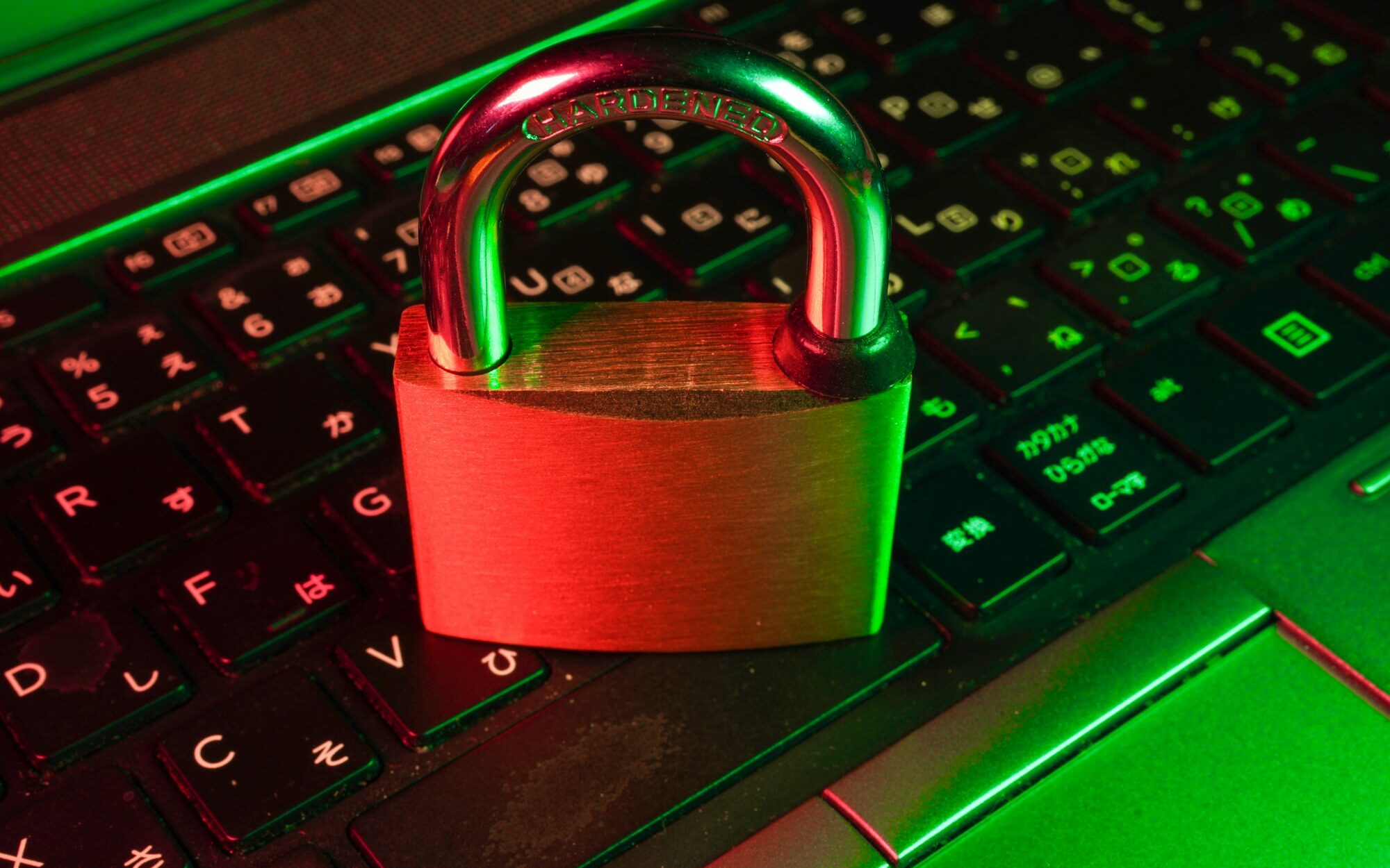 Rotes Vorhängeschloss auf einer beleuchteten Laptop-Tastatur