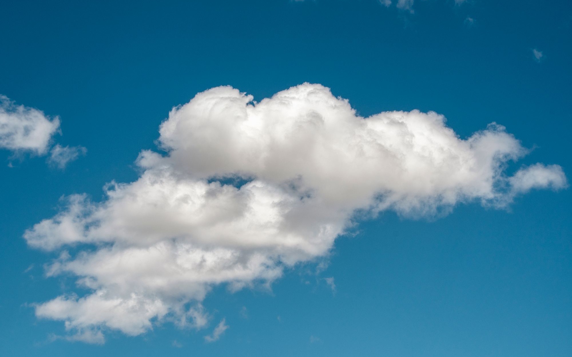 Weiße Haufenwolke vor tiefblauem Himmel an einem klaren Tag